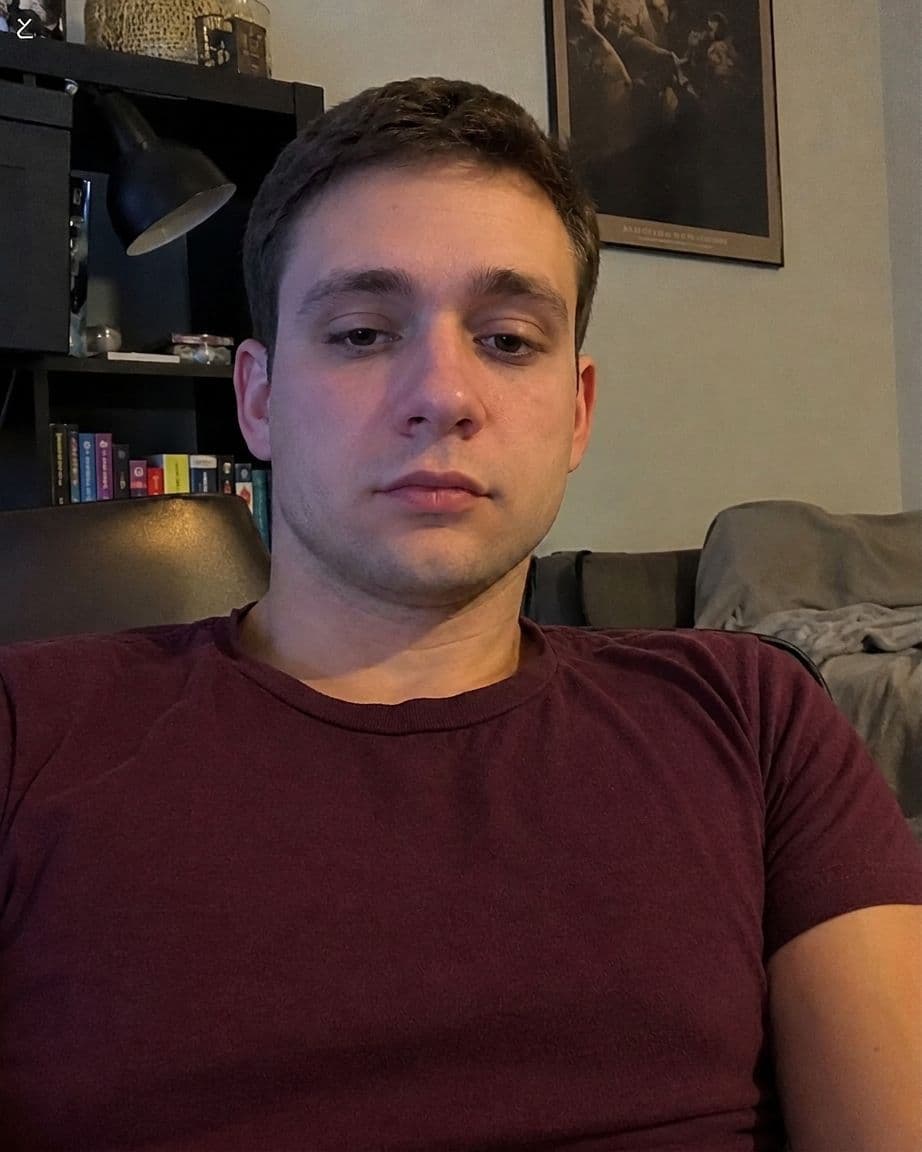 After photo: portrait of a male with a sharper, more defined lower face sitting on his couch
