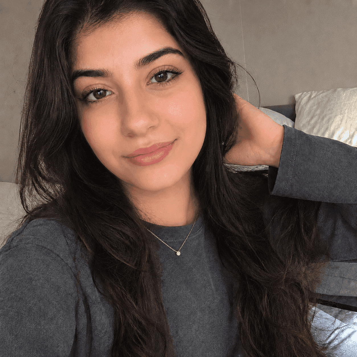 Before jawline filter: dark-haired woman in a beauty pose selfie with a round jawline