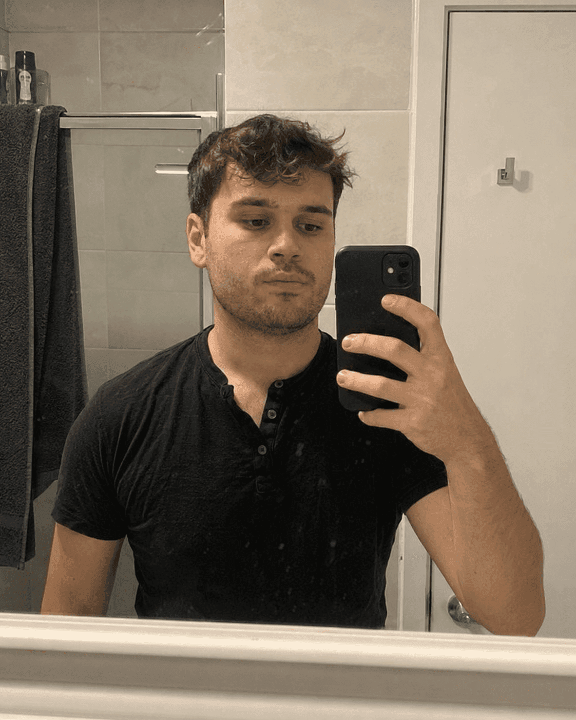 Before AI jawline editor: man's bathroom mirror selfie with a soft, round jawline